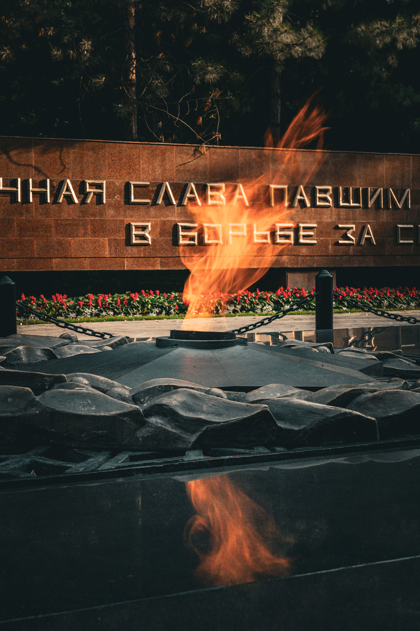 A cinematic photo of a gas fire coming from a firepit of black rocks