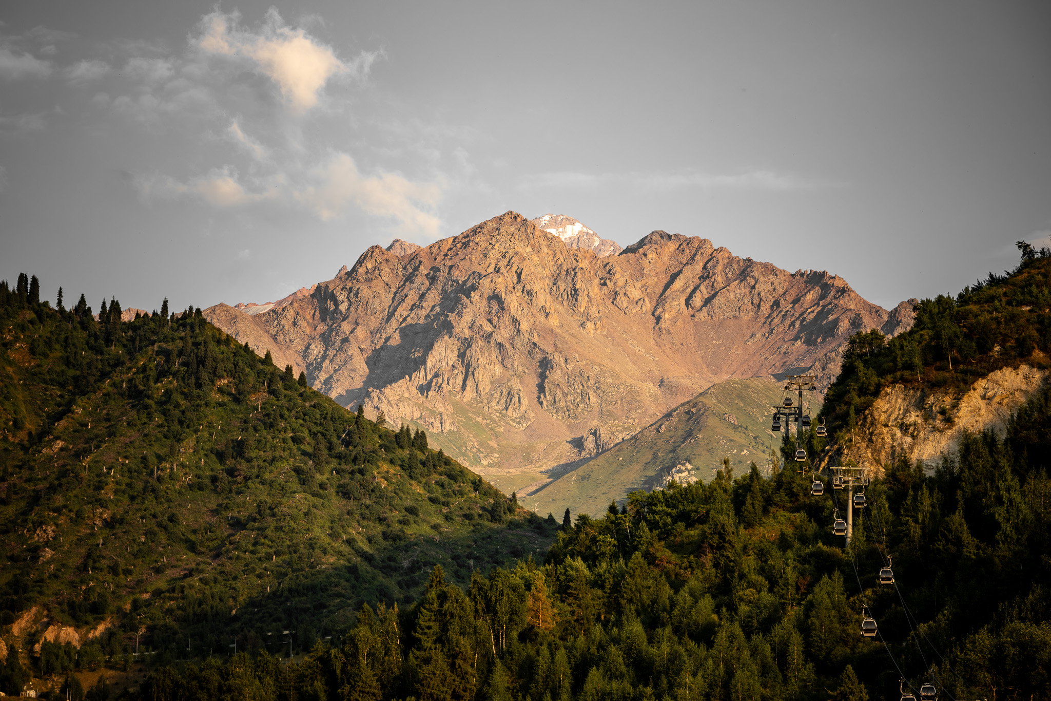 A photo of a mountain landscape with the forest on the sides and a mountain in the middle